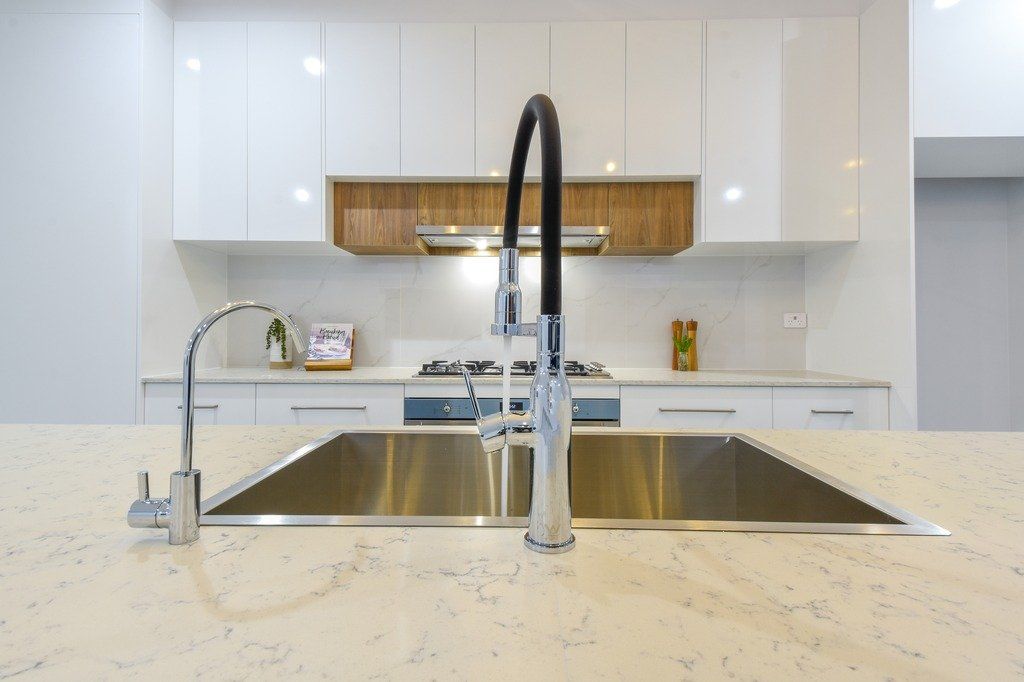 A kitchen with a stainless steel sink and a faucet.