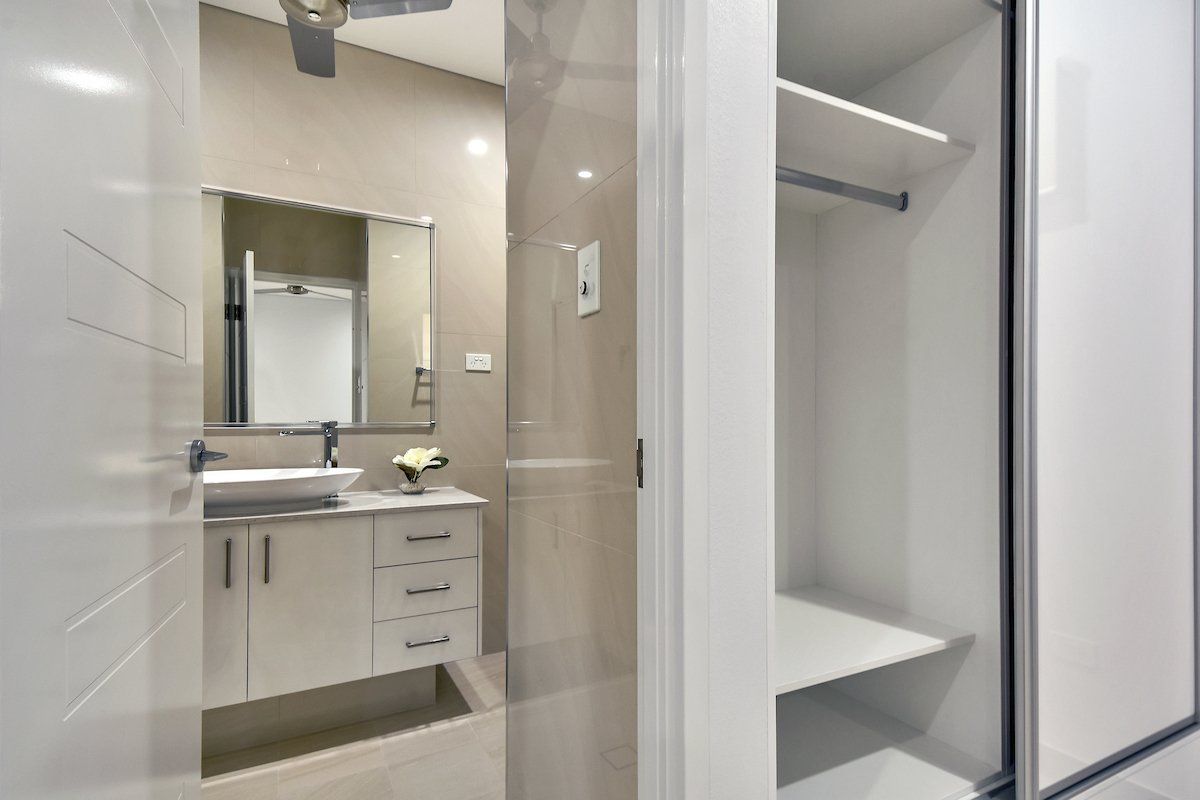 A bathroom with a sink , mirror and sliding glass door.