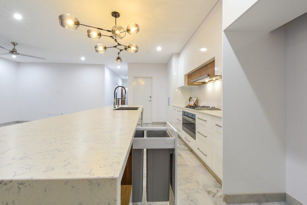 A kitchen with a long counter top and a sink.