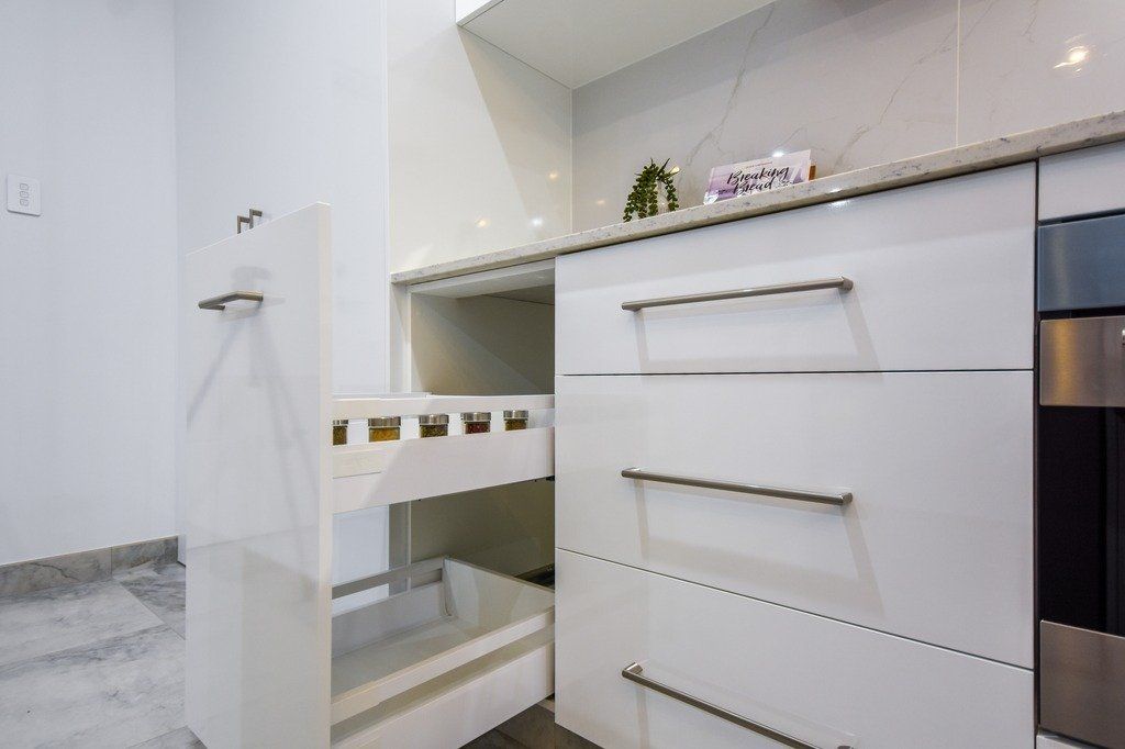 A kitchen with white cabinets and stainless steel appliances.
