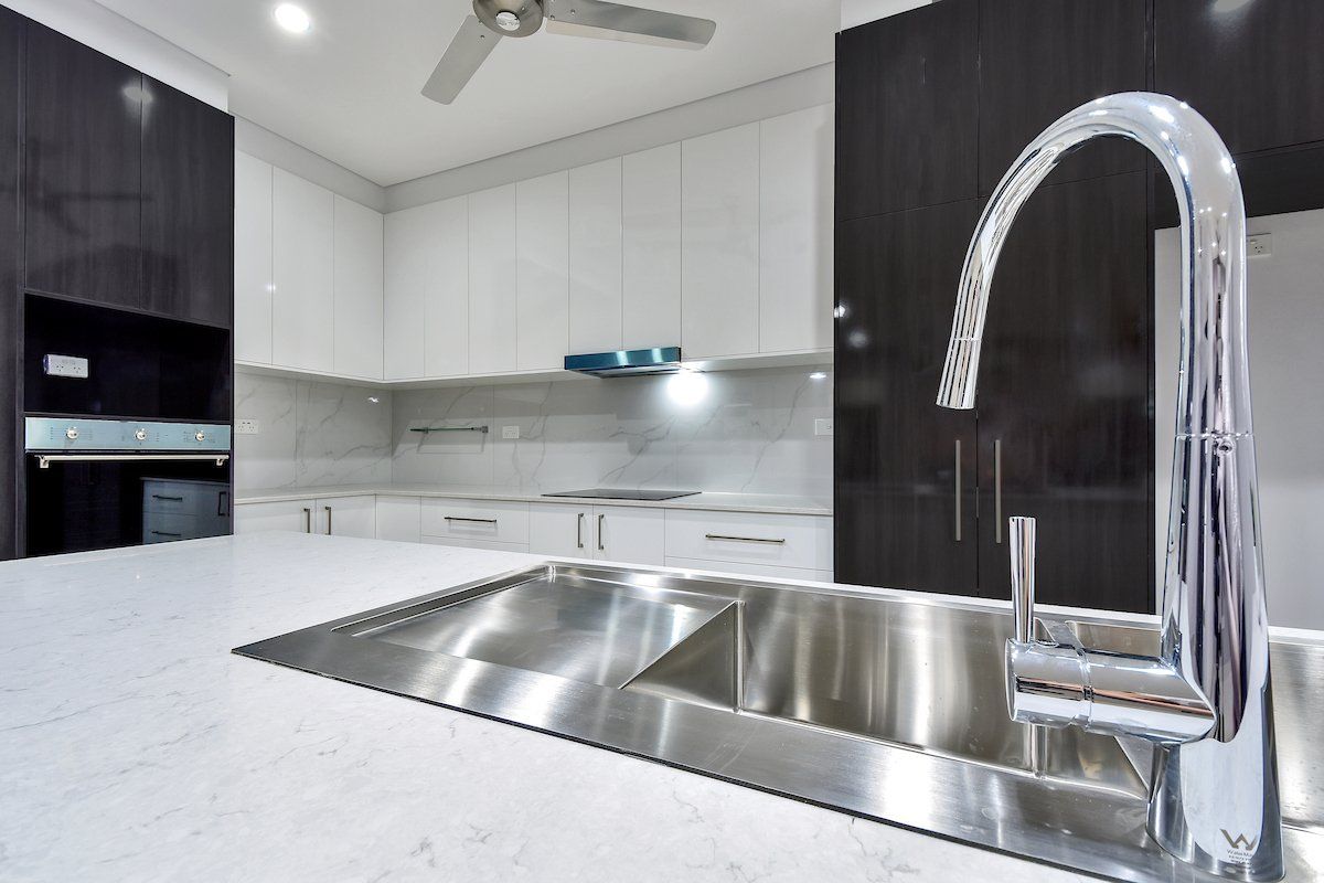 A kitchen with a stainless steel sink and a faucet