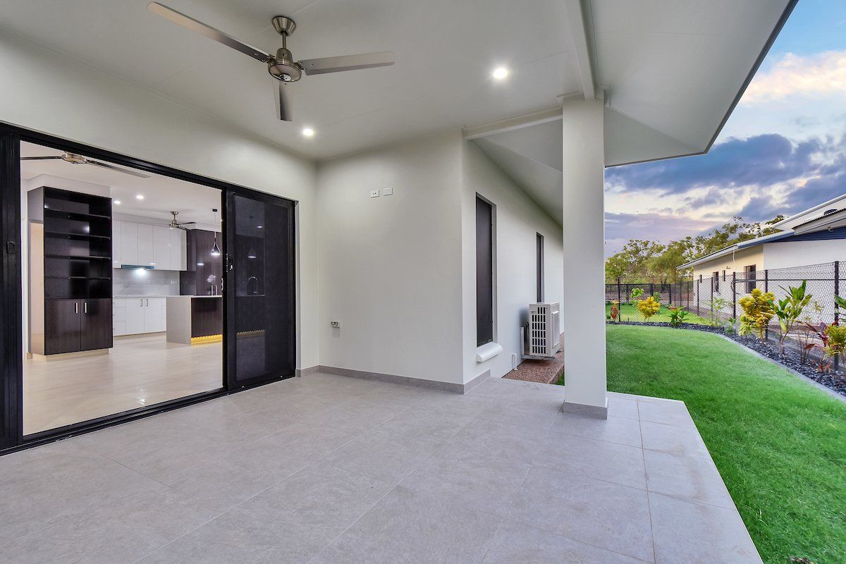A patio with sliding glass doors and a ceiling fan in a house.