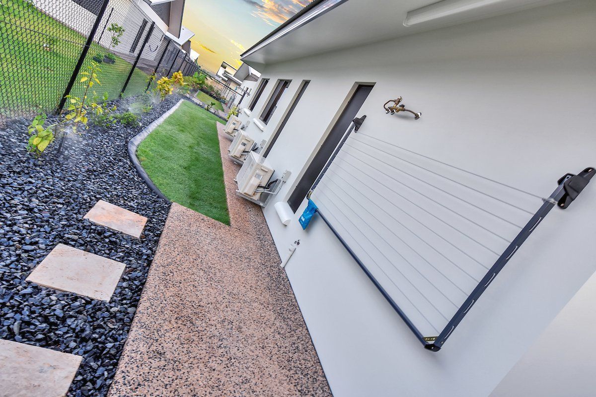 A white house with a fence and a walkway in front of it.