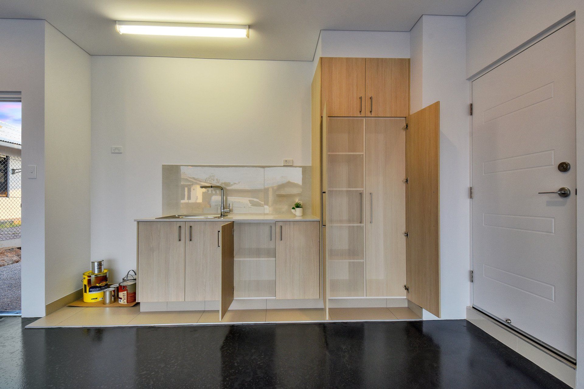 A kitchen with wooden cabinets and a black floor