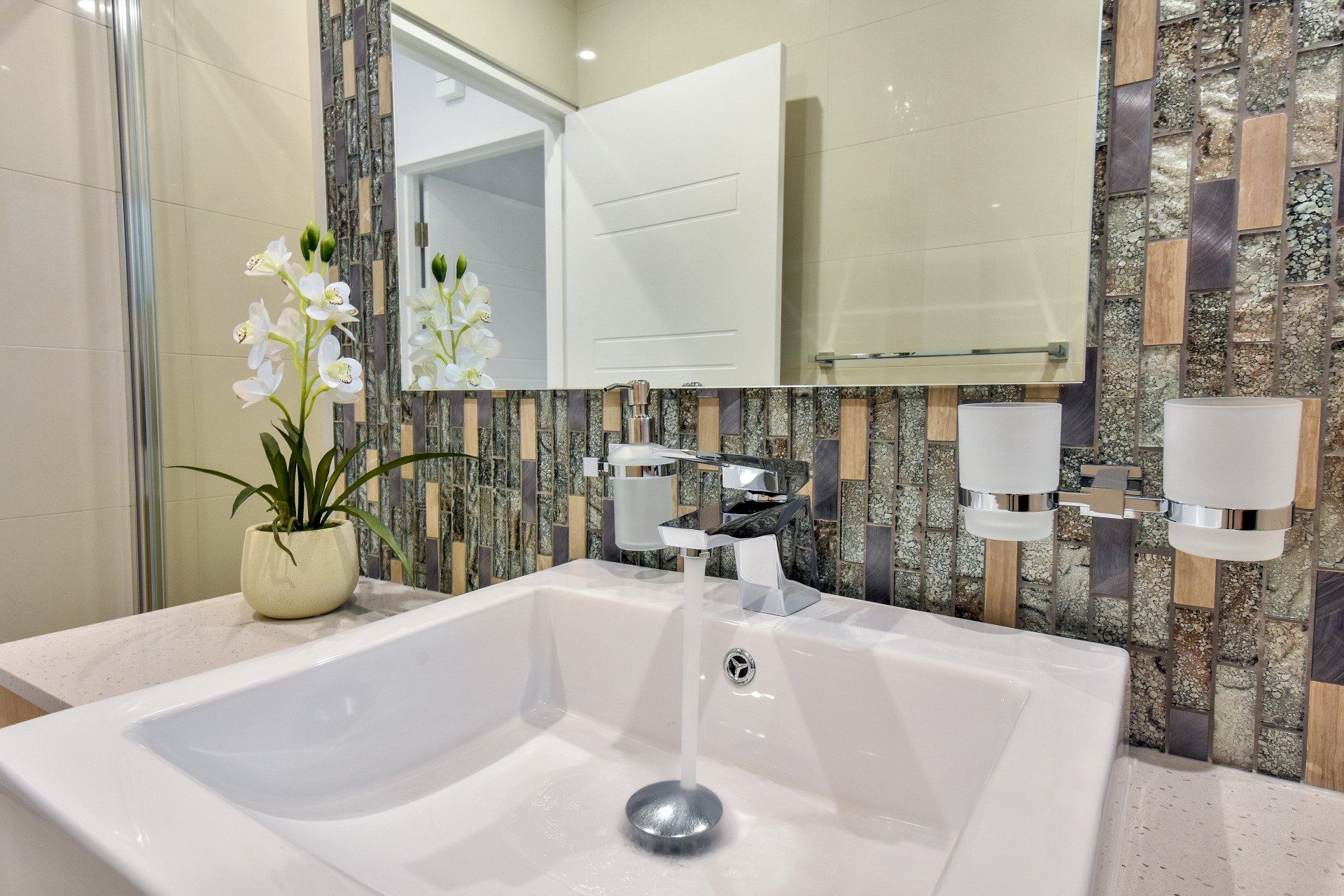 A bathroom sink with water running out of it and a mirror.