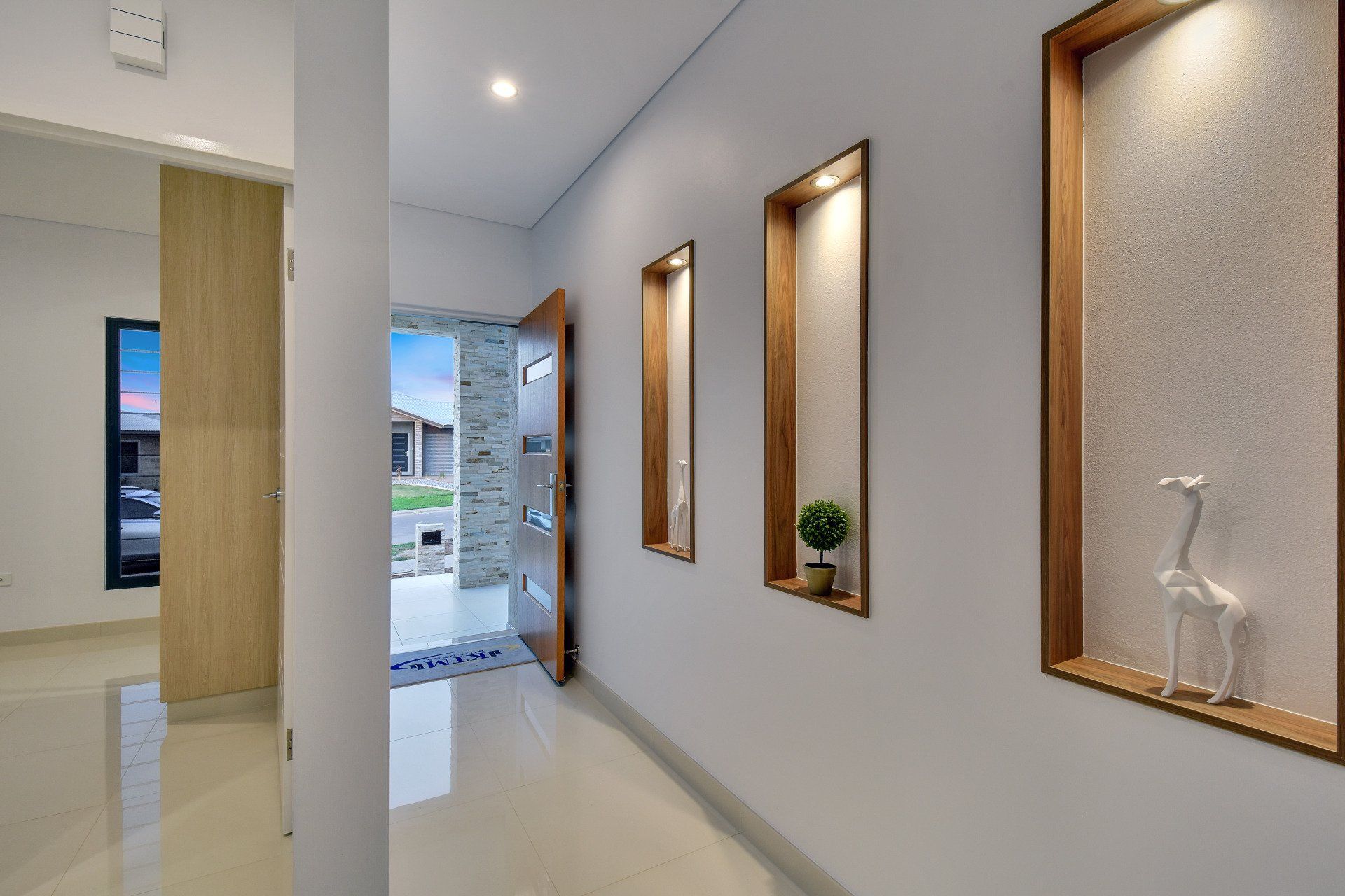 A hallway with a statue of a giraffe on the wall