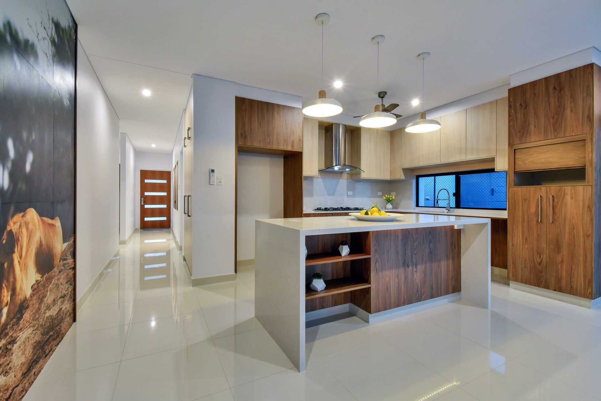 A kitchen with a large island and a picture of a cow on the wall.