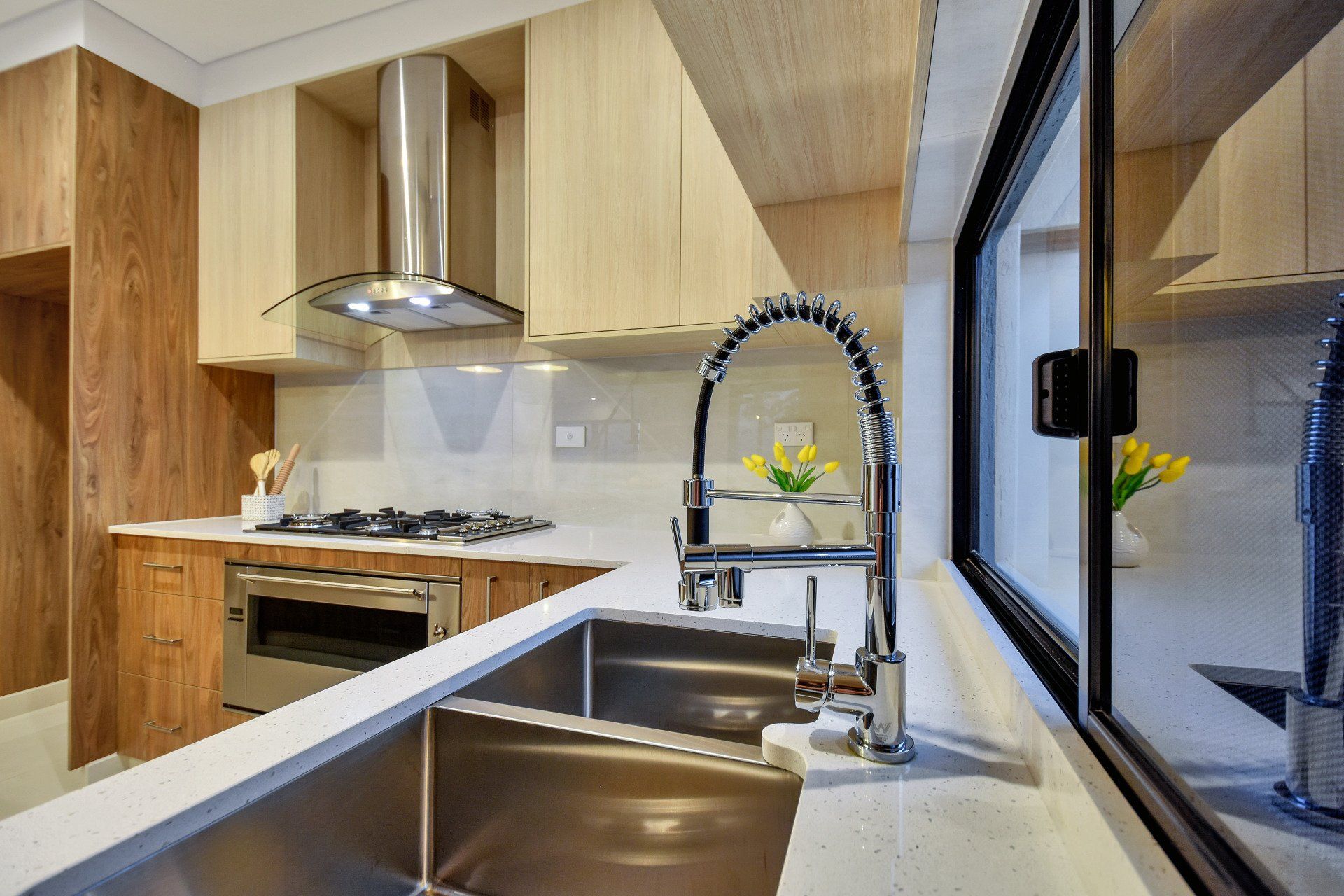A kitchen with a stainless steel sink and a window