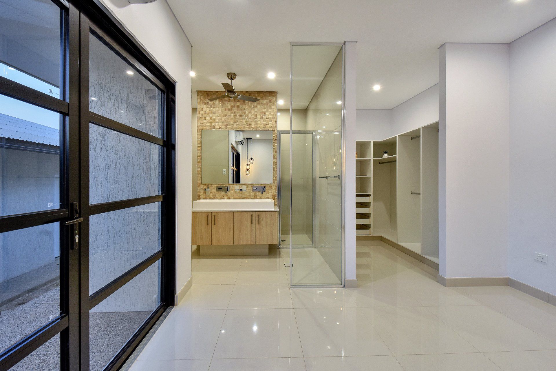 A bathroom with a walk in shower and a sink.