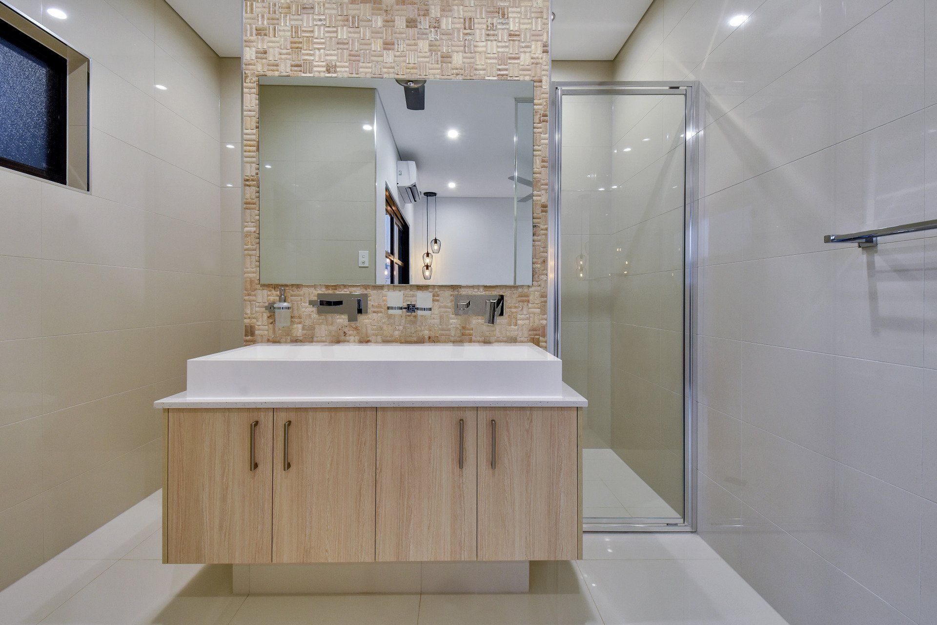 A bathroom with a sink , mirror and walk in shower