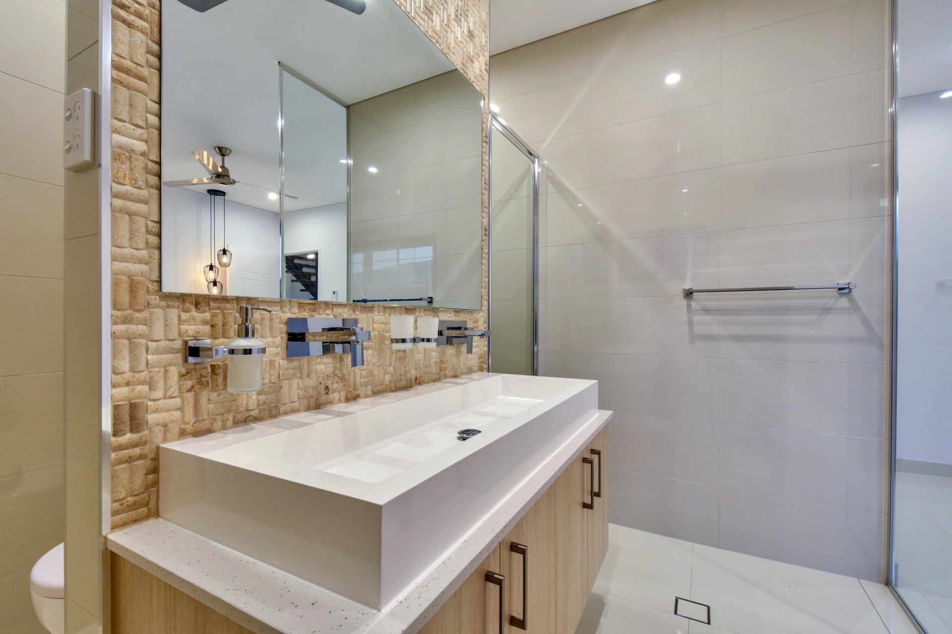 A bathroom with a sink , mirror and walk in shower.