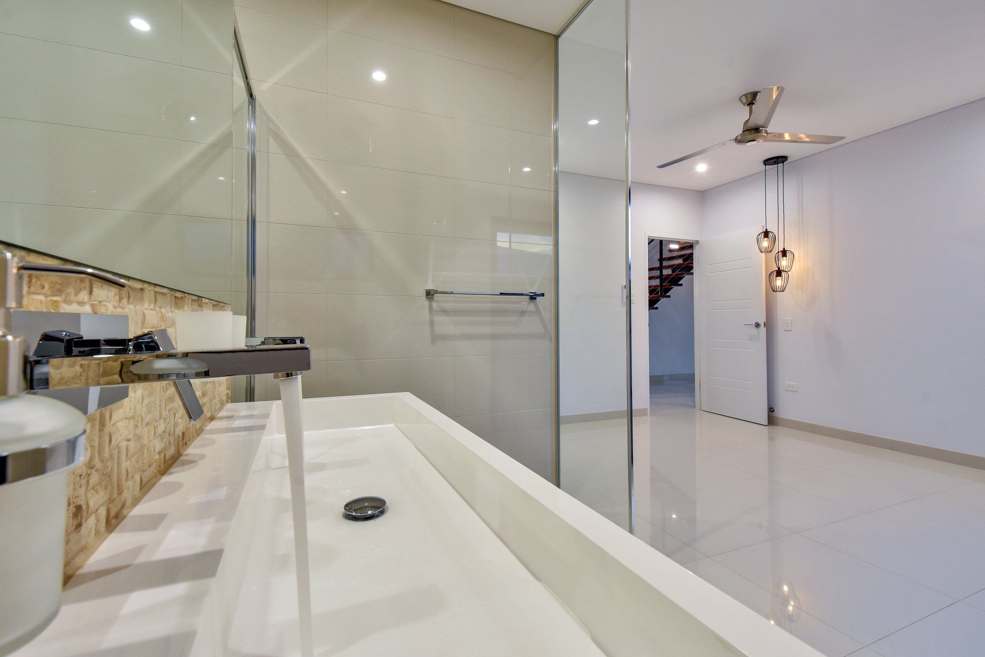 A bathroom with a sink , mirror and walk in shower.