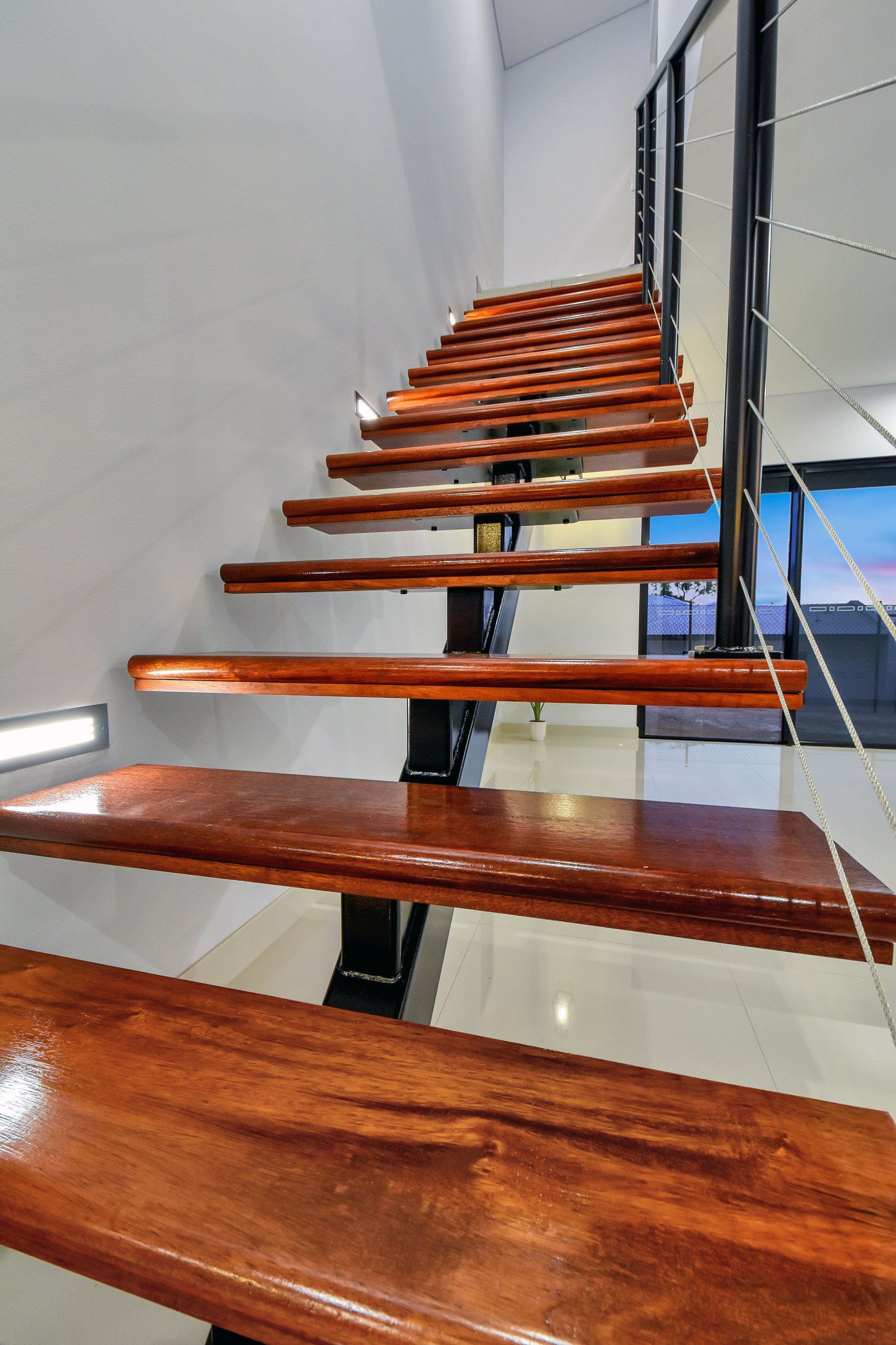 A wooden staircase with a metal railing in a house.