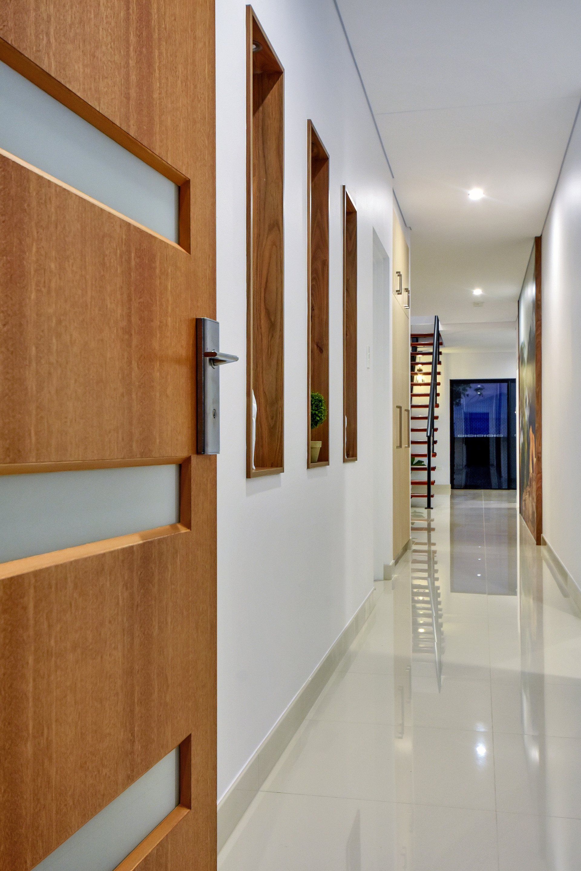 A hallway with a wooden door and white walls