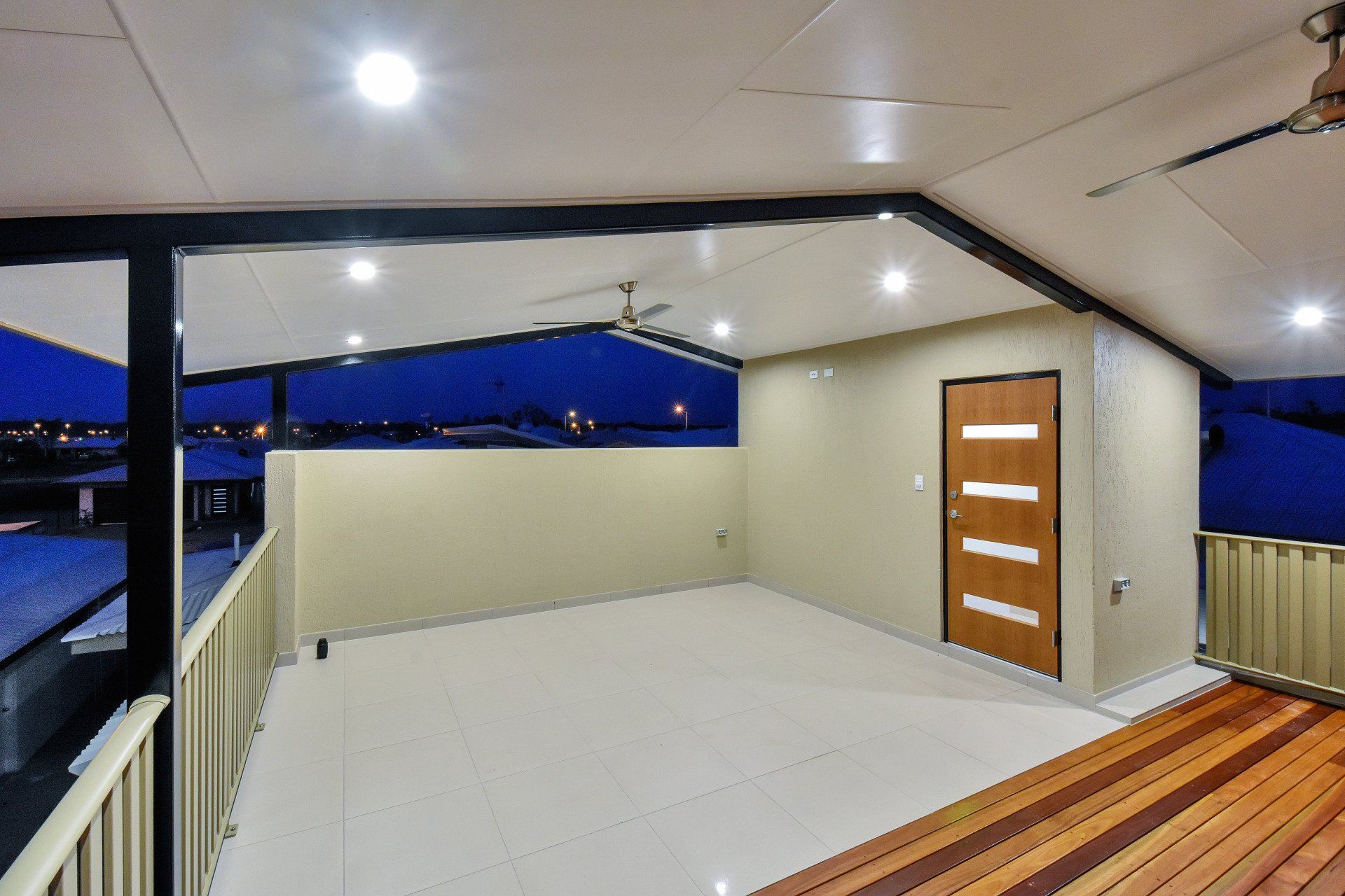 An empty deck with a door and a ceiling fan