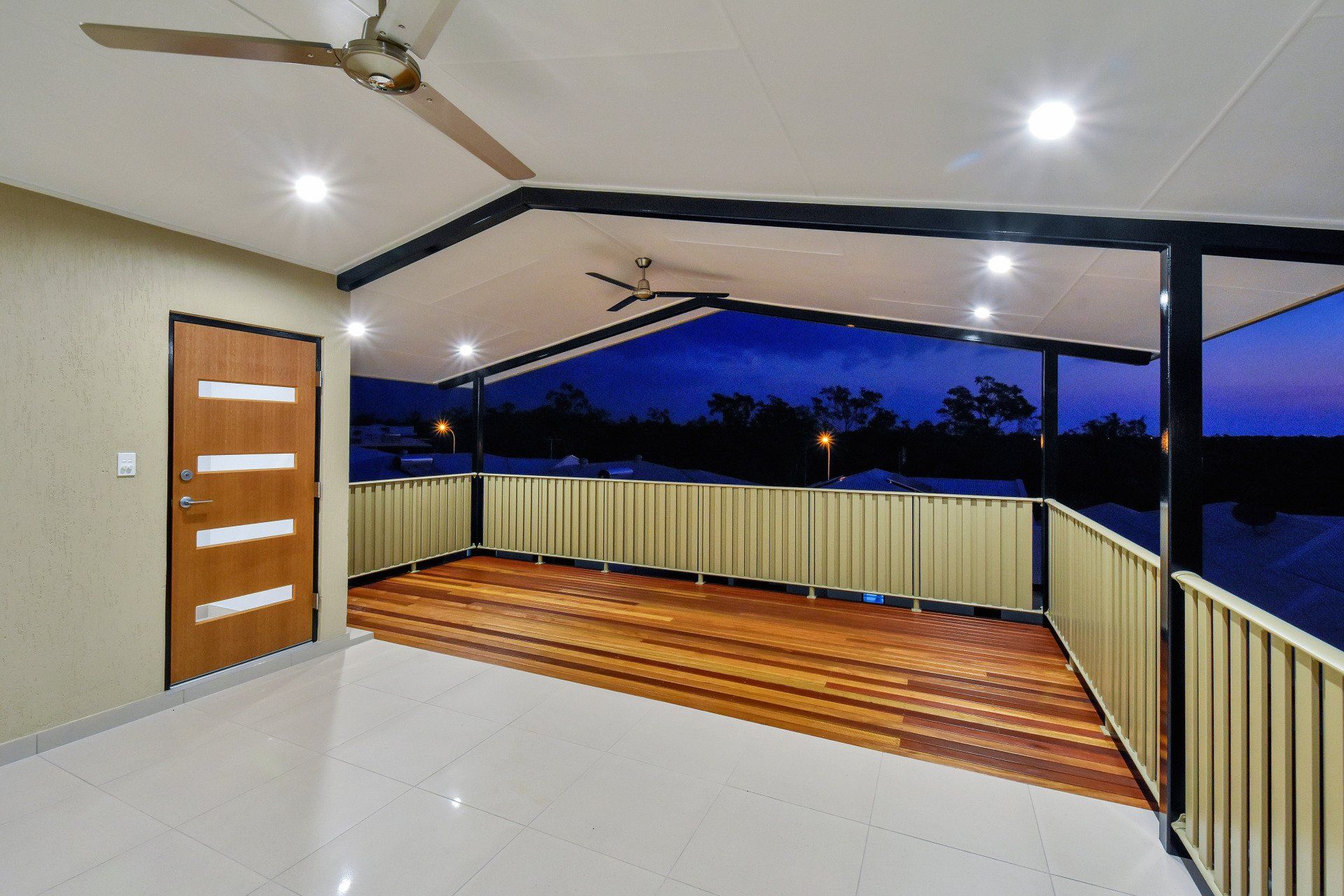An empty room with a wooden deck and a ceiling fan
