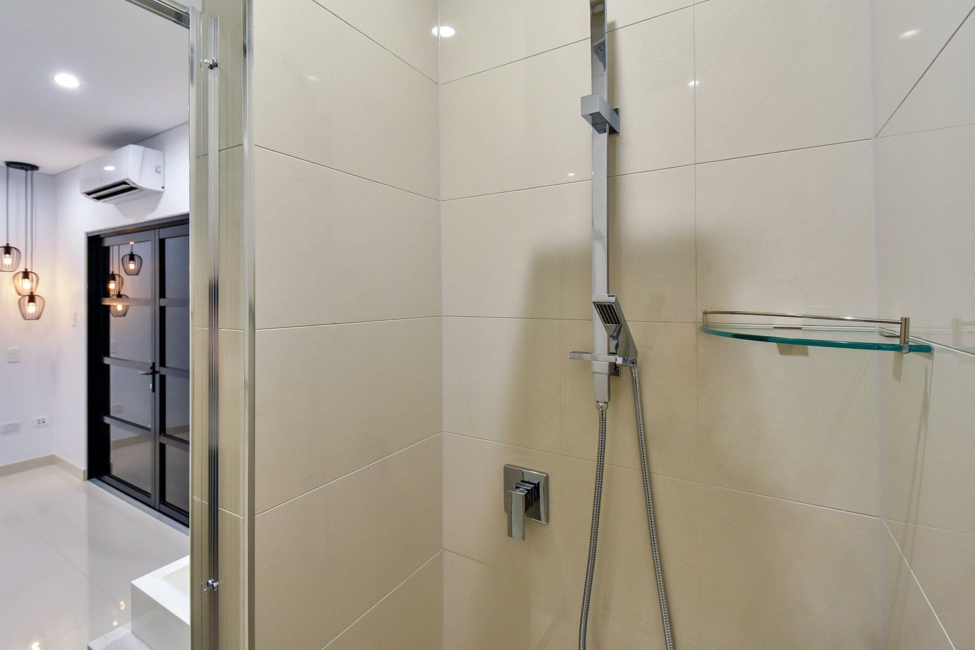 A bathroom with a shower and a glass door.