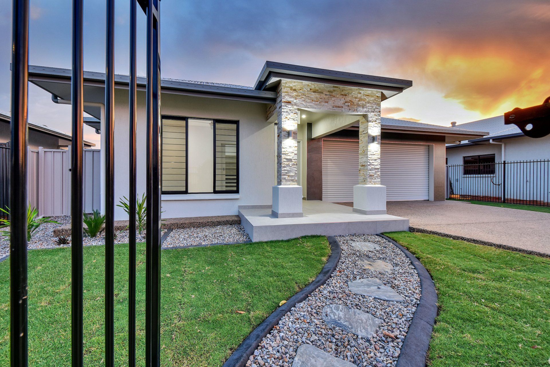 A house with a fence and a walkway leading to it