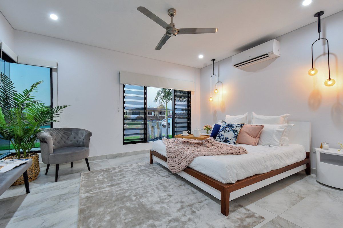 A bedroom with a large bed and a ceiling fan.