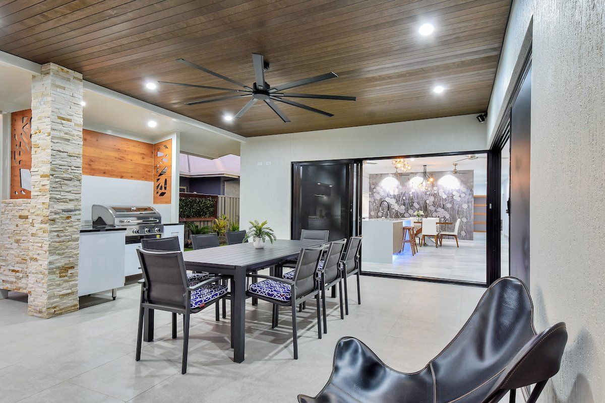 A dining room with a table and chairs and a ceiling fan.