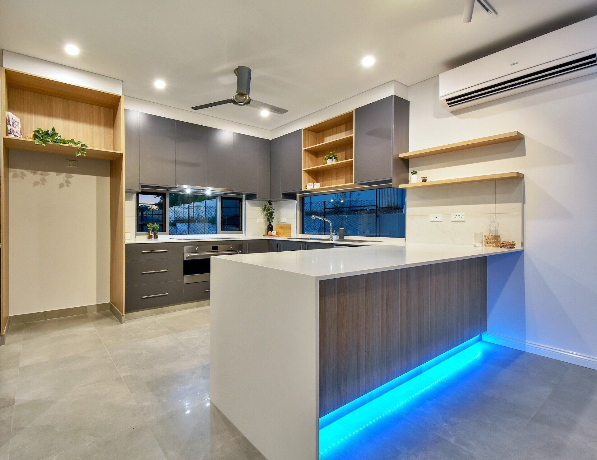 A kitchen with a large island and a ceiling fan.
