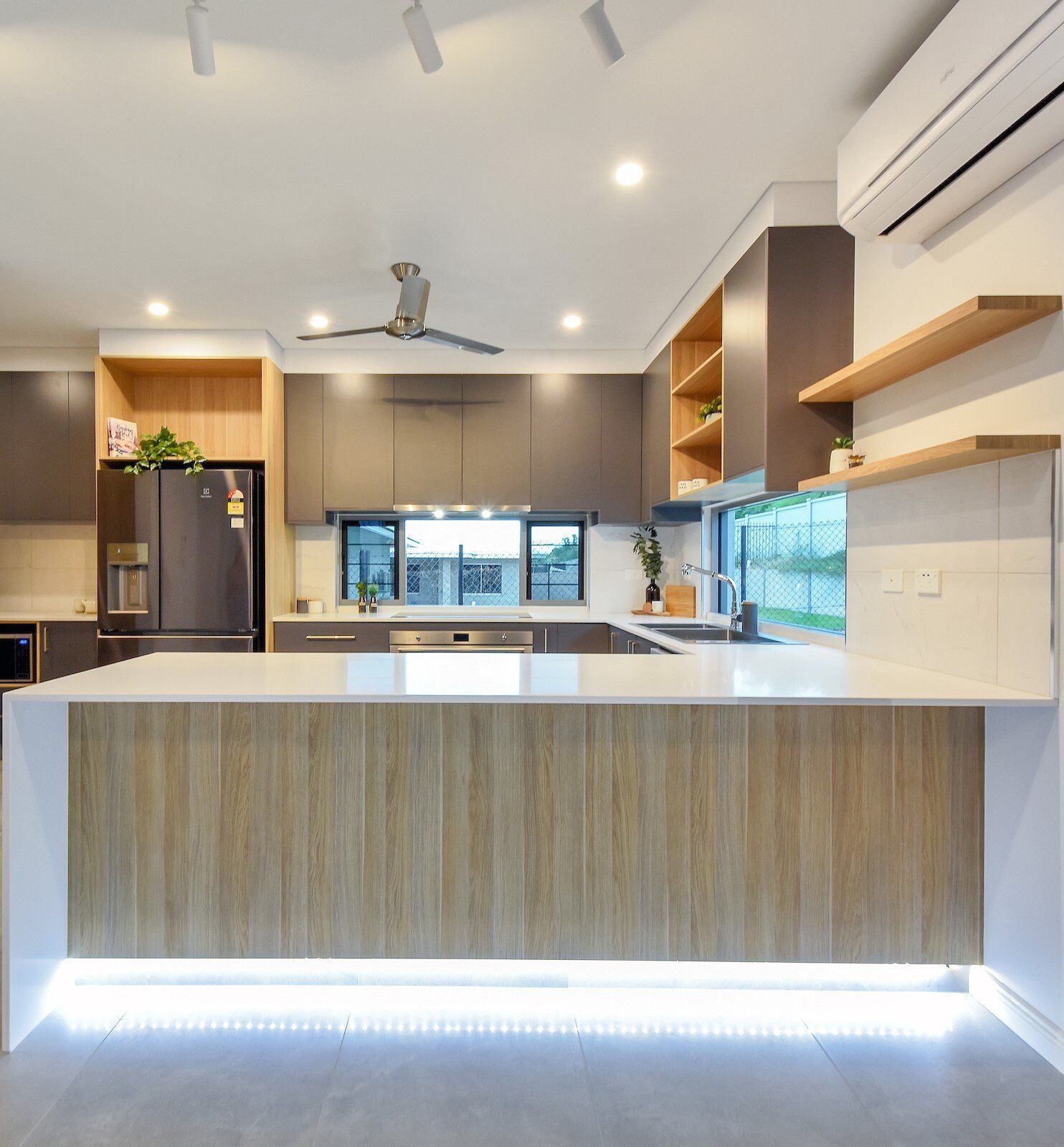 A kitchen with a large island and a ceiling fan