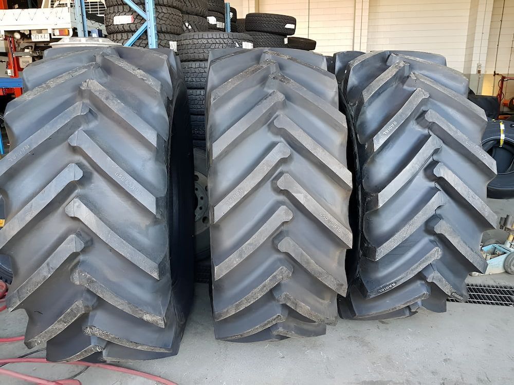 Three Tractor Tires Are Stacked On Top Of Each Other In A Warehouse — Goodyear Autocare Bowen in Bowen, QLD
