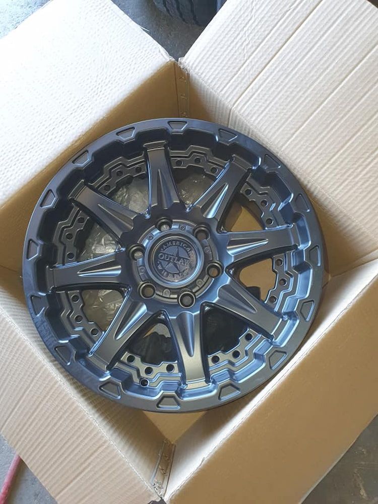 A Black Wheel Is Sitting In A Cardboard Box — Goodyear Autocare Bowen in Bowen, QLD