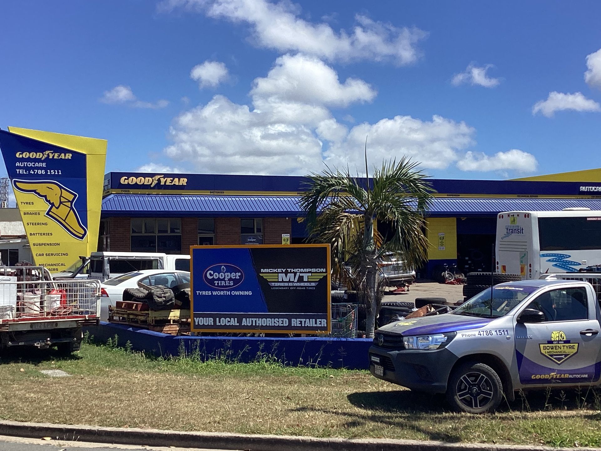 A Person Is Writing On A Clipboard Under The Hood Of A Car — Goodyear Autocare Bowen in Bowen, QLD