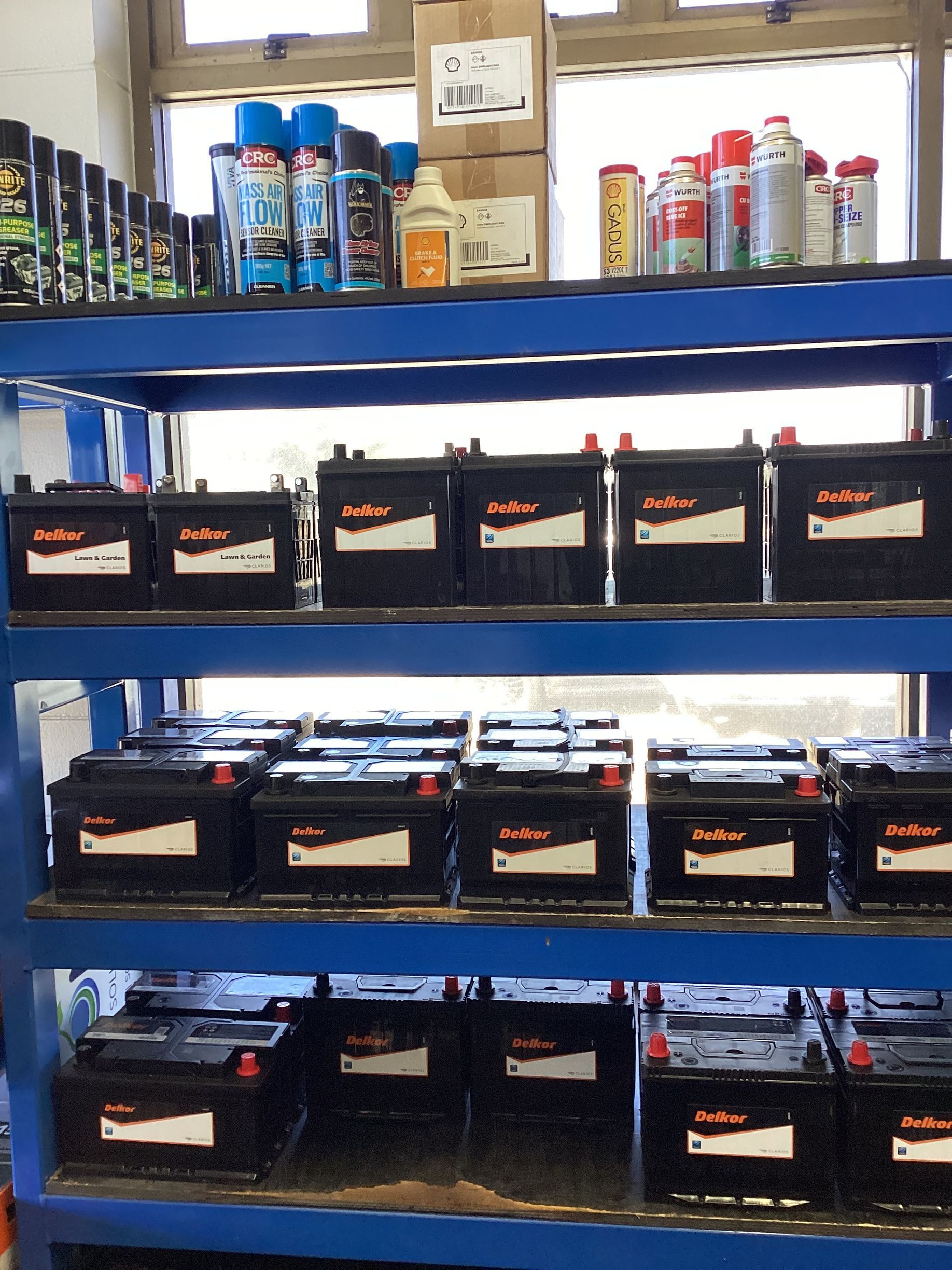 A Man Is Fixing A Car Battery With A Wrench — Goodyear Autocare Bowen in Bowen, QLD