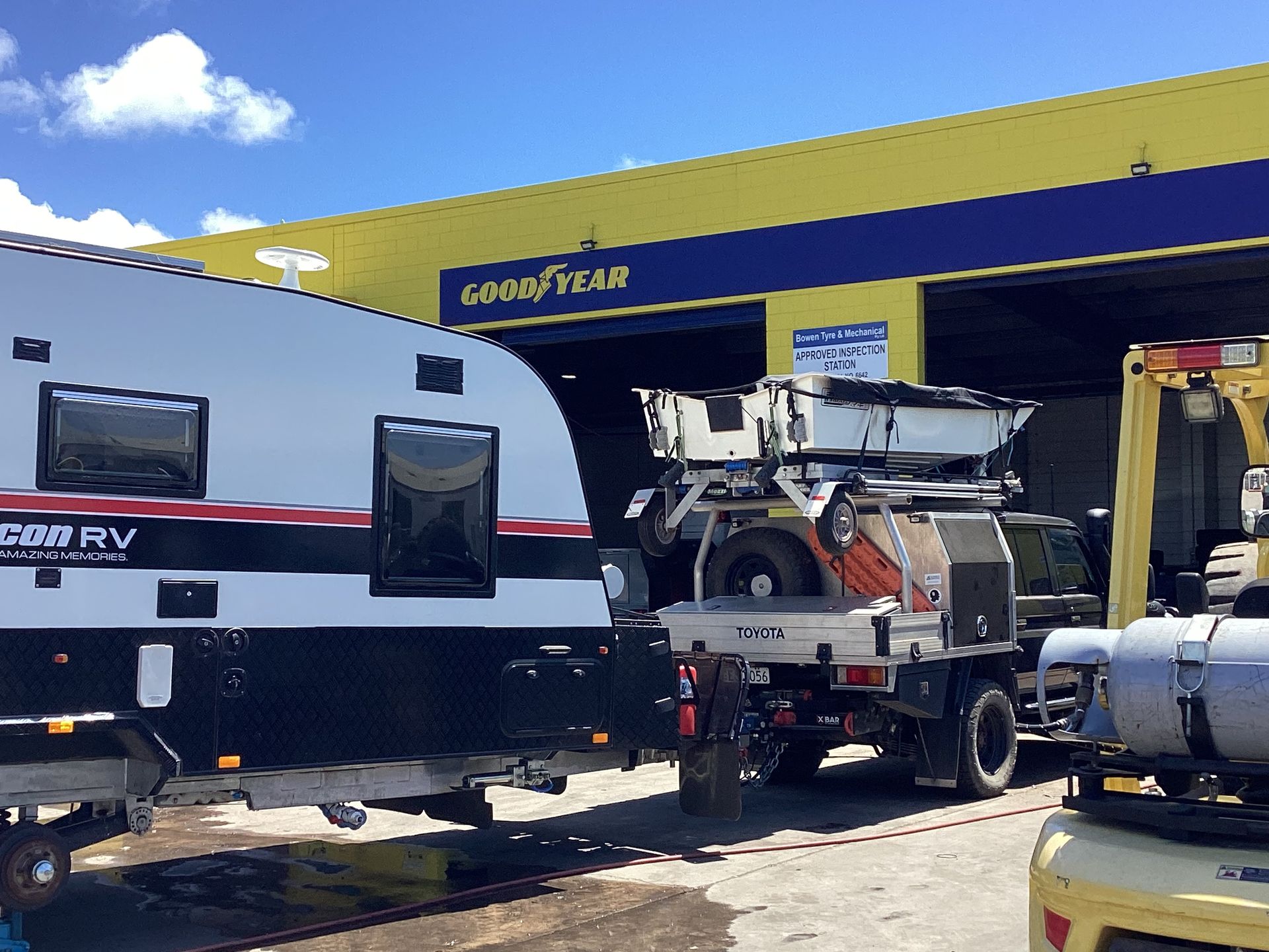 A Man Is Standing Next To A Truck Holding A Clipboard — Goodyear Autocare Bowen in Bowen, QLD