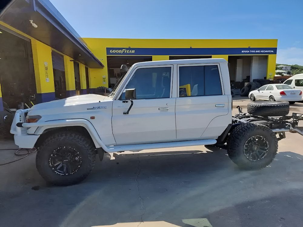 A White Truck Is Parked In Front Of A Yellow Building — Goodyear Autocare Bowen in Bowen, QLD