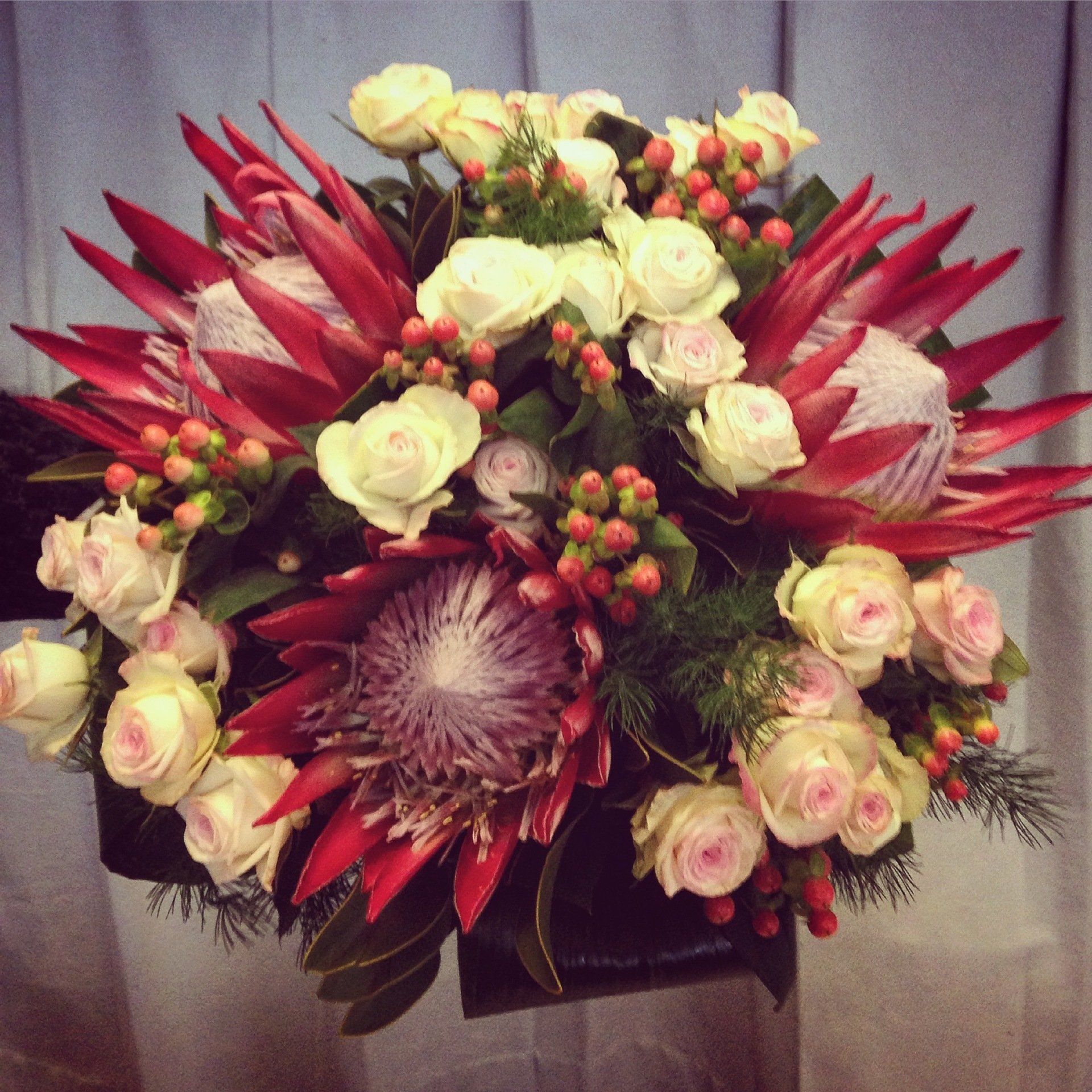 Un mazzo di fiori rosa e rossi in una scatola nera