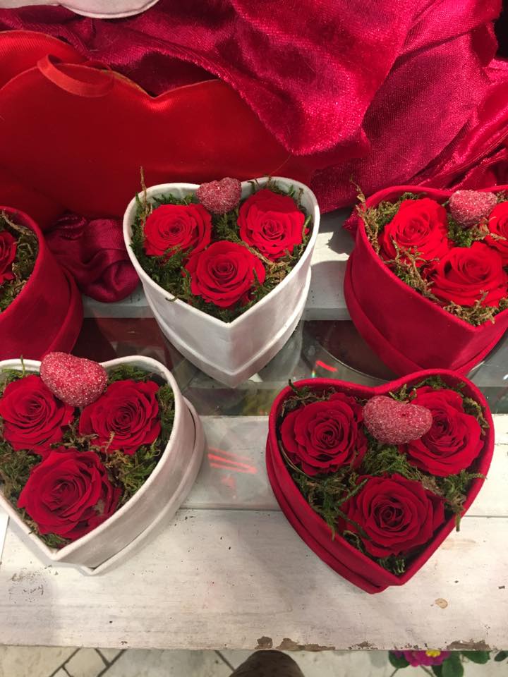 Una persona sta impacchettando un mazzo di fiori nella carta.