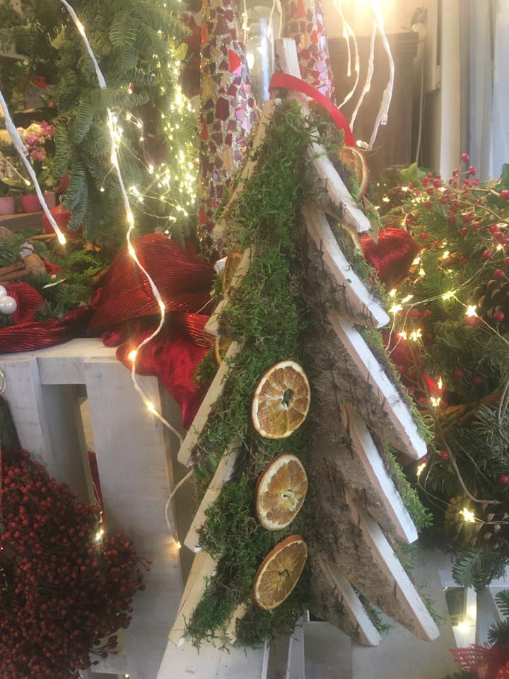 Un albero di Natale di legno con muschio e arance secche.