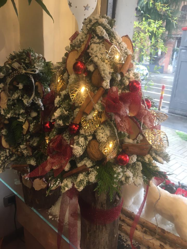 Un piccolo albero di Natale è appoggiato su un tavolo di vetro.