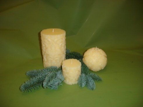 Tre candele sono appoggiate su un tavolo verde.