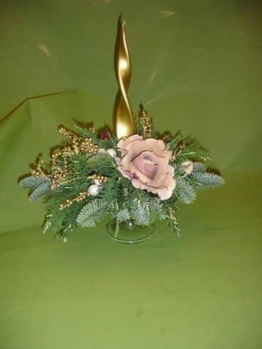 Un vaso pieno di fiori e una candela su un tavolo.