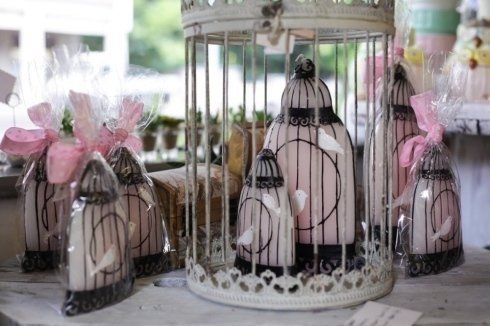 Una gabbia per uccelli piena di candele è appoggiata su un tavolo.