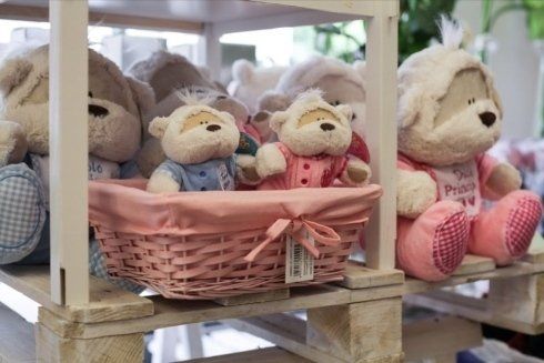 Un gruppo di animali di peluche sono sistemati in cesti su uno scaffale.