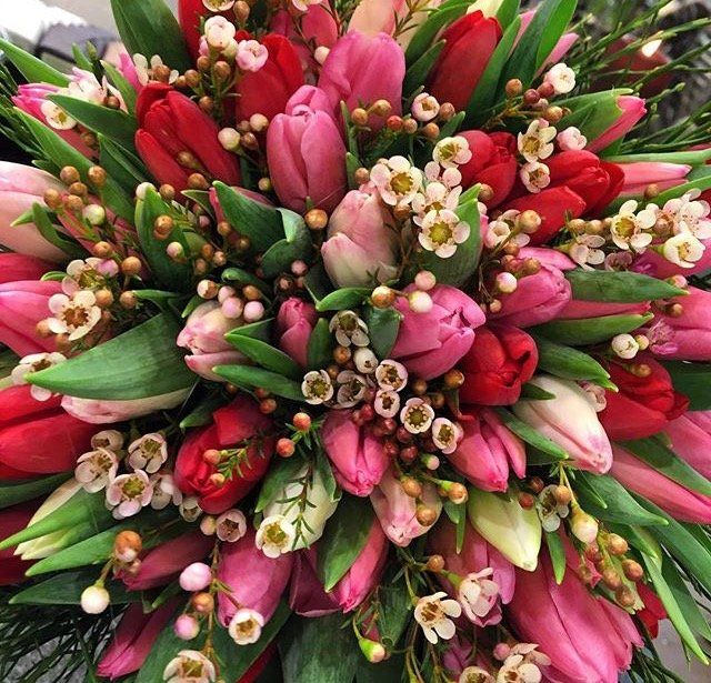 Un mazzo di fiori rosa e rossi con foglie verdi