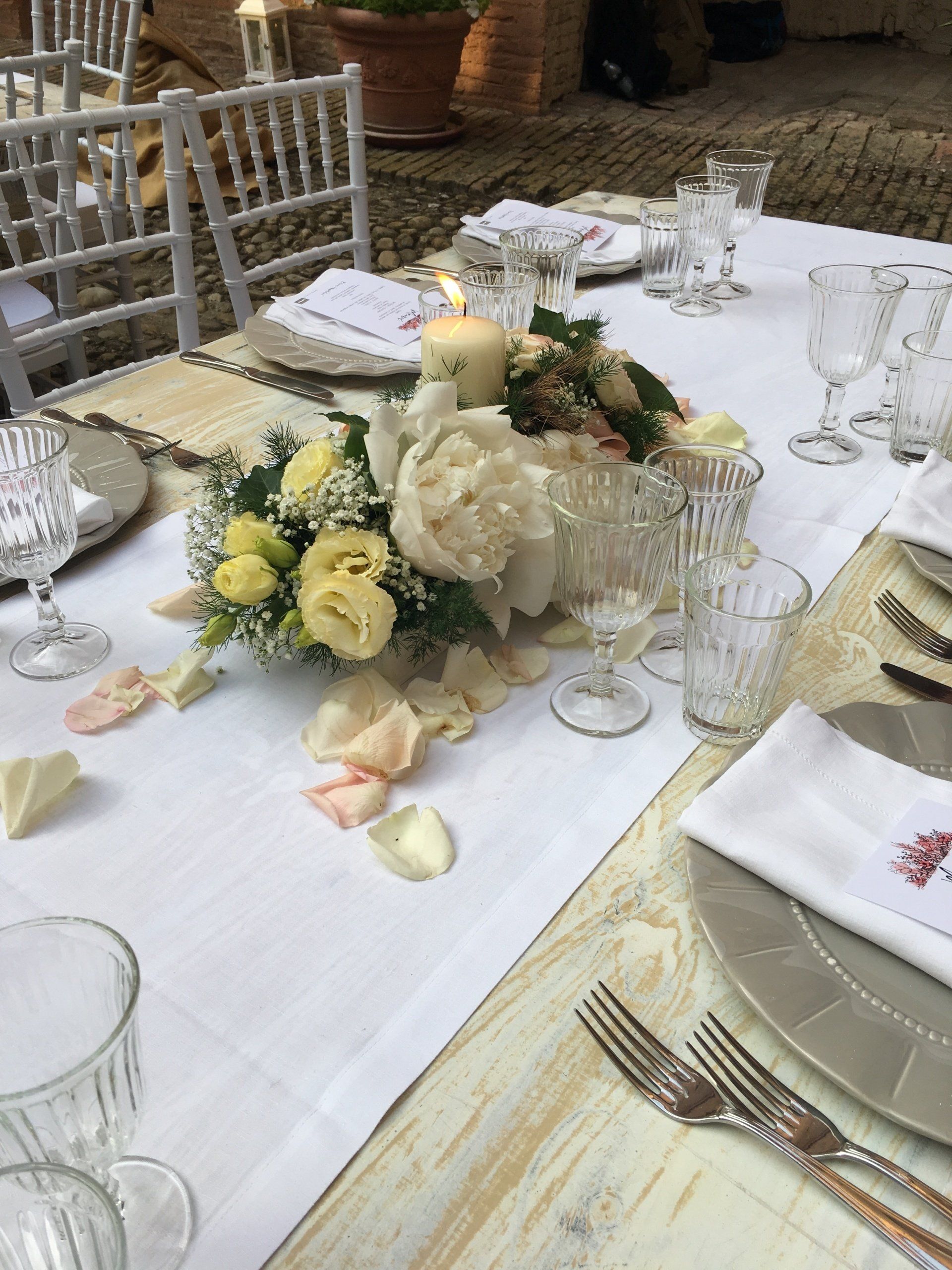 Un lungo tavolo decorato con fiori e candele per un ricevimento di nozze.