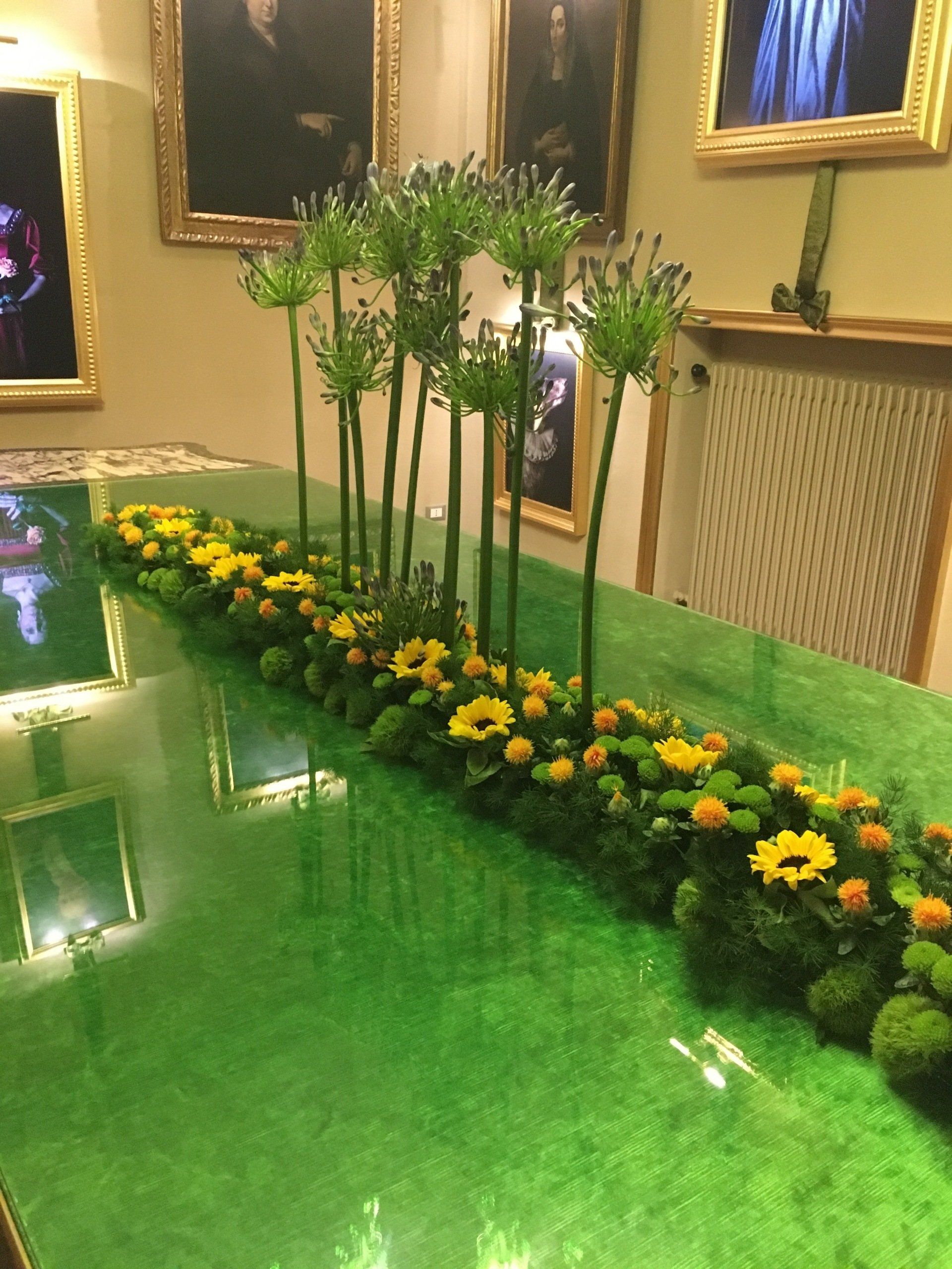 Si sta svolgendo una cerimonia nuziale sotto un gazebo con un tappeto rosso che conduce ad esso.