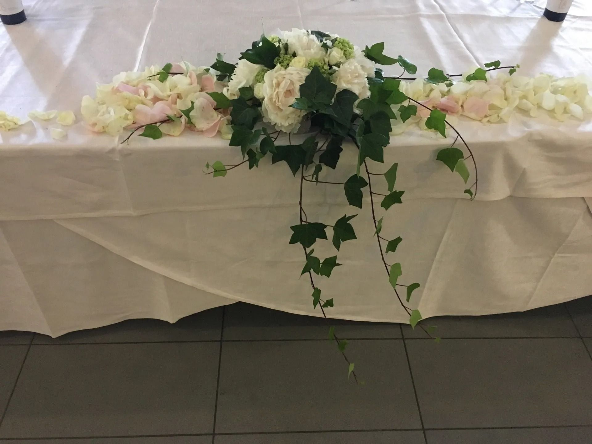 Una donna sta creando un mazzo di fiori su un tavolo.