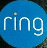 A blue ring logo is on a black surface.