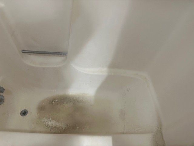 a bathtub with water coming out of it in a bathroom . | Erie, PA | Peterson's Property Maintenance