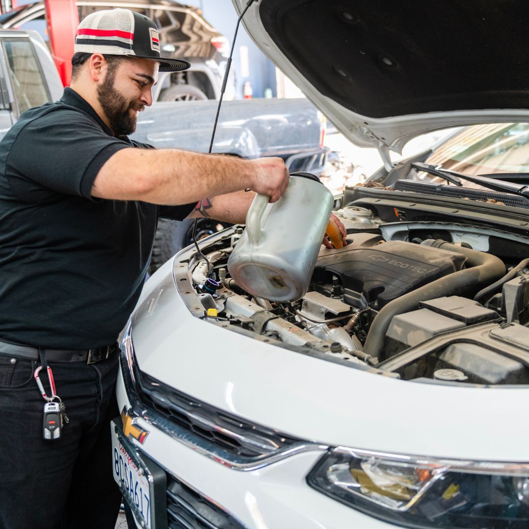 Mechanic Performing Maintenance on a White Car | Stevens Creek Muffler & Auto Repair