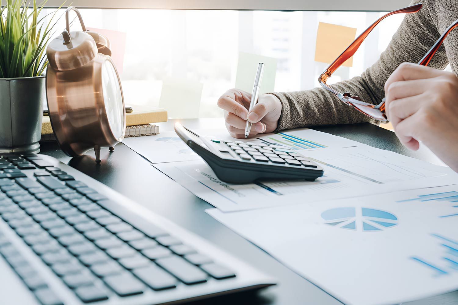 Accountant Hand Holding Pen Working On Calculator — Whitson Dawson Accountants in North Whitsundays, Queensland