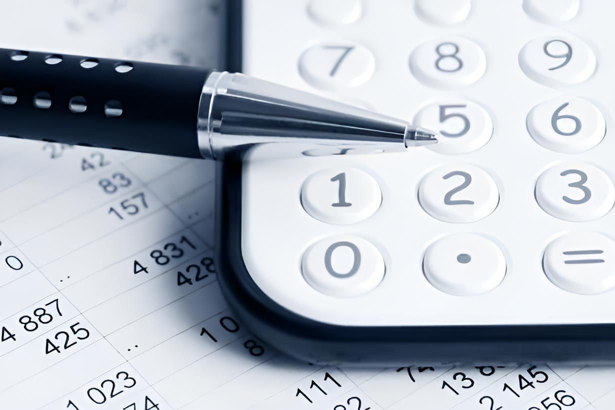 Calculator With Pen And Accounting Sheet — Whitson Dawson Accountants in Mackay, QLD