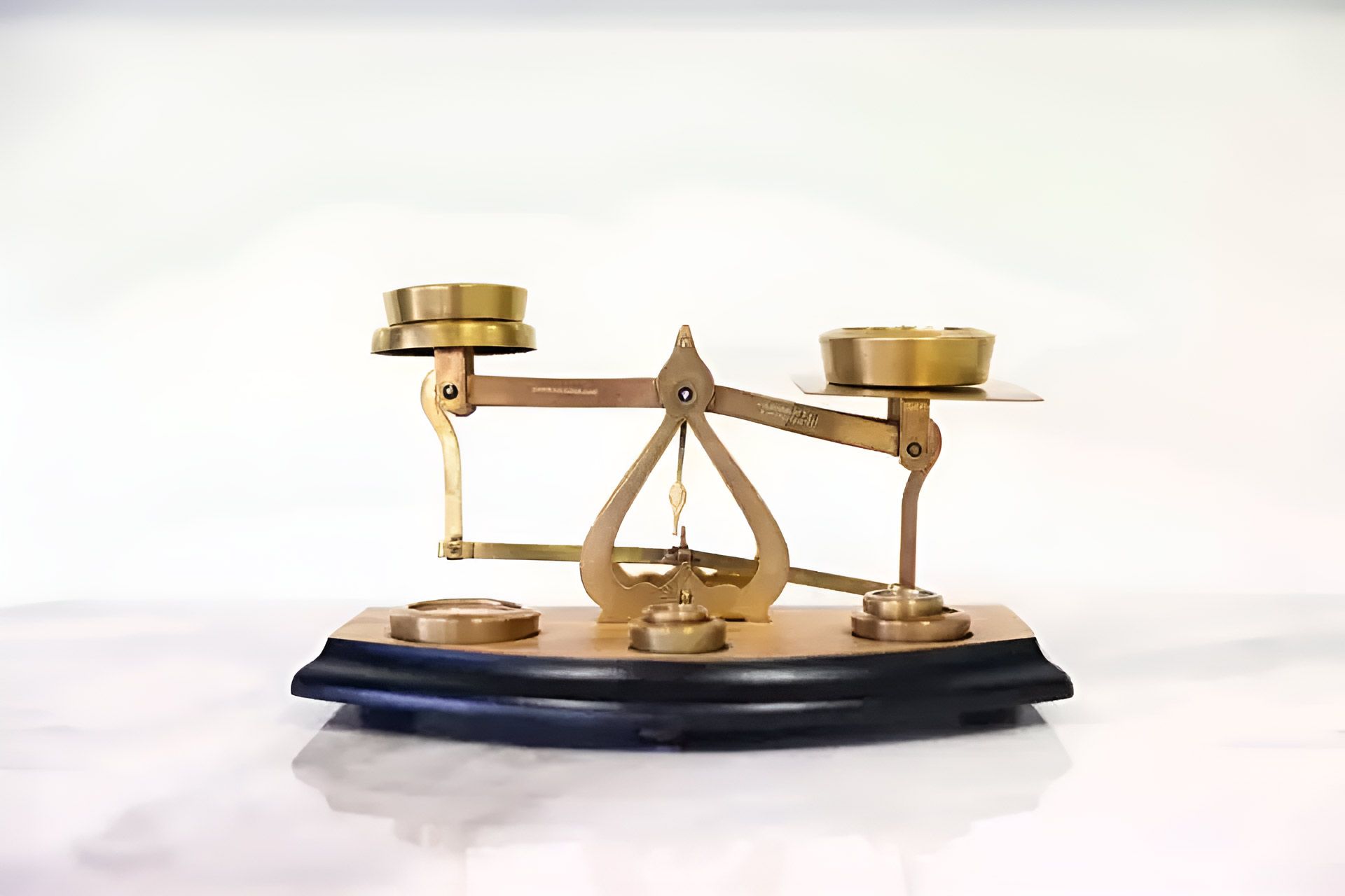 A Brass Scale Is Sitting On A Wooden Base On A White Surface — Whitson Dawson Accountants in Mackay, QLD
